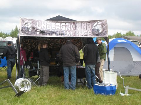 2000 Ford E350 - An outdoor event features a tent with a performance banner and several people milling about.