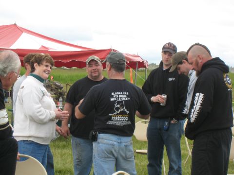 2000 Ford E350 - A group of people are socializing outdoors under a large tent at an event.