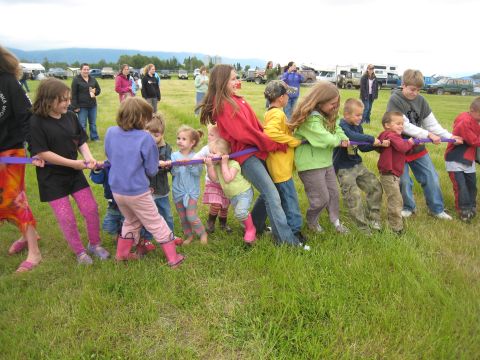 2000 Ford E350 - A group of children are engaged in a tug-of-war competition on a sunny day.