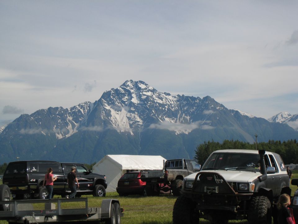 White and grey off-road SUV with snorkel and winch, parked in front of a mountain