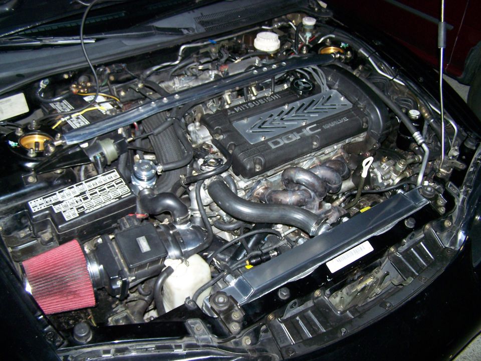 Mitsubishi 4G63 engine with DOHC 16-valve cover, aftermarket intake, and exhaust manifold