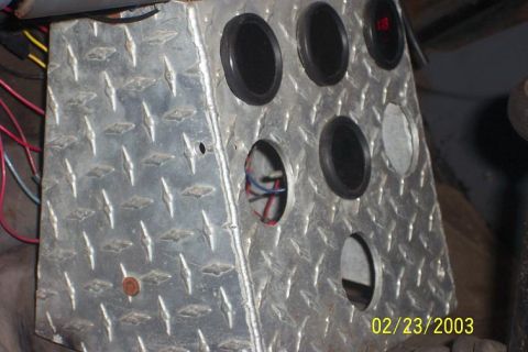diamond plate panel with several gauge holes, some with gauges installed, wires visible