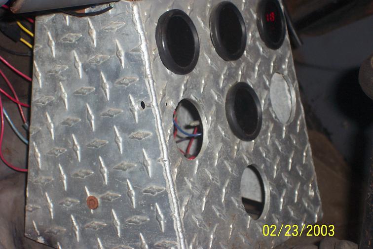diamond plate panel with several gauge holes, some with gauges installed, wires visible