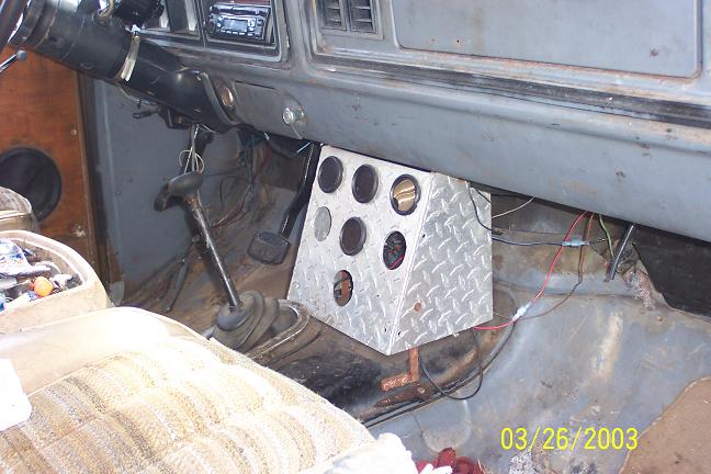 Interior of a 1978 Ford Bronco showing the dashboard, steering wheel, gear shifter, and a custom aluminum gauge pod