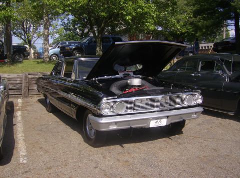 1970 Ford Ranchero - This black sedan, likely a 1964 model, is displayed with its hood open, its engine compartment.