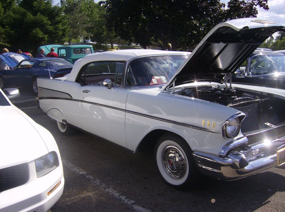 White 1957 Chevrolet Bel Air with hood open, parked next to other cars