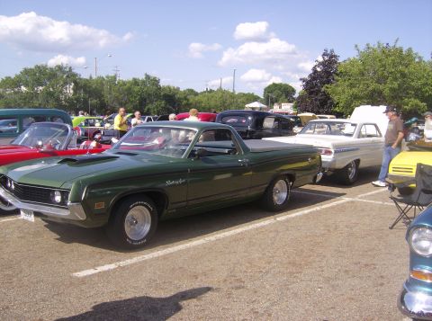 1970 Ford Ranchero - A green 1970 Ford Ranchero is parked at a car show with other vehicles around it.