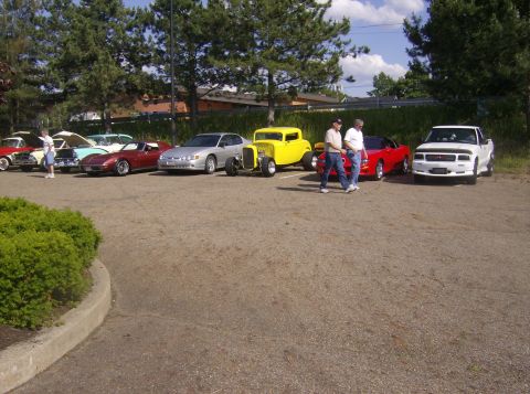 1970 Ford Ranchero - A collection of vehicles, including a hot rod and a pickup truck, are parked in an outdoor lot.