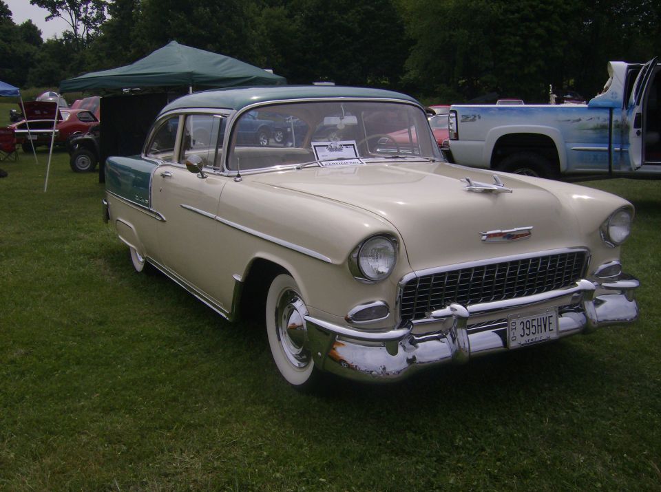 1955 Chevrolet Bel Air, beige and teal, parked on grass.