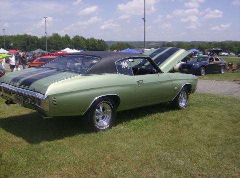 1970 Ford Ranchero - A light green 1970 Chevrolet Chevelle SS is displayed with its hood open at an outdoor car show.