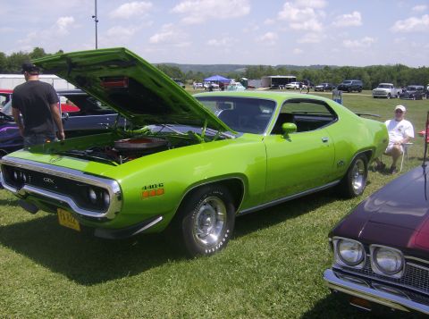 1970 Ford Ranchero - A lime green 1971 Plymouth GTX 440-6 is displayed with its hood open at a car show.