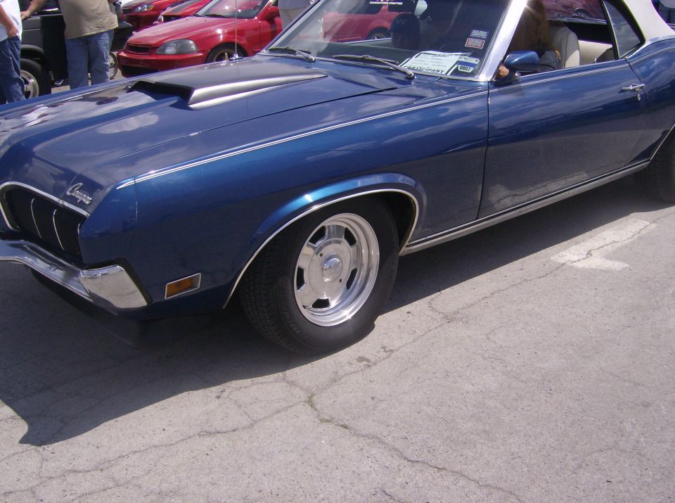 Dark blue classic car with hood scoop and chrome accents.
