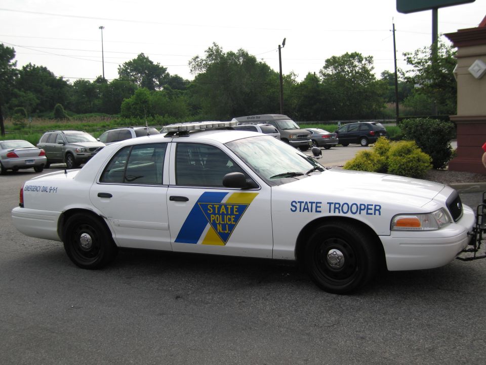 White Ford Crown Victoria NJ State Police trooper car, passenger side, in parking lot