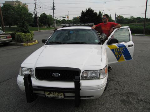 1991 Ford LTD Crown Victoria - Front view of a white Ford Crown Victoria New Jersey State Police car with a push bar and license plate reading SP-A125, a man standing alo…