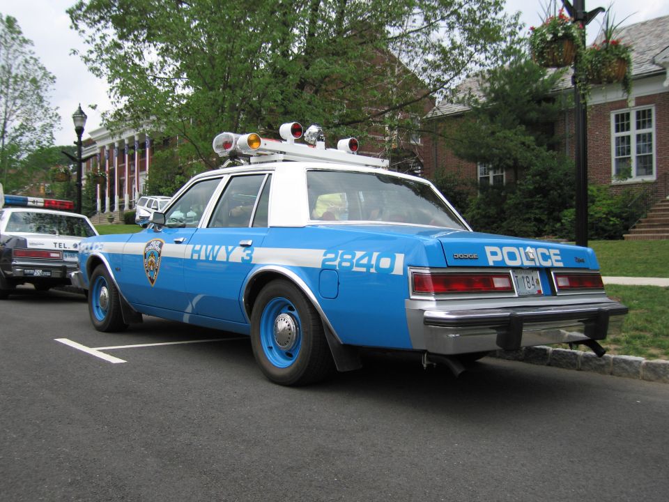 Blue and white NYPD Highway Dodge police car parked at curb, rear three-quarter