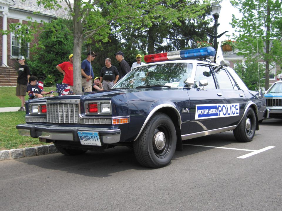 Dark blue North Haven Police Dodge sedan front three-quarter, people standing nearby