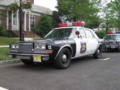 1991 Ford LTD Crown Victoria - Black-and-white Essex County Correction Center sedan shown front three-quarter with a red roof lightbar, parked at a curb.
