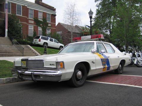 1991 Ford LTD Crown Victoria - White NJ State Police Dodge Royal Monaco shown front three-quarter with chrome grille and red roof lightbar at a curb.