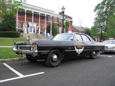 1991 Ford LTD Crown Victoria - Black Plymouth Ohio State Highway Patrol sedan shown front three-quarter with chrome grille and gold winged door emblem.
