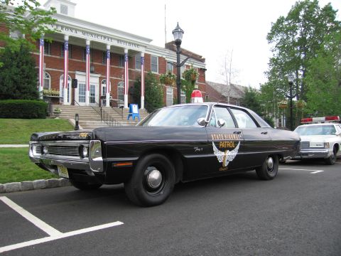 1991 Ford LTD Crown Victoria - Front three-quarter view of a black Plymouth Ohio State Highway Patrol sedan parked outside the Verona Municipal Building.