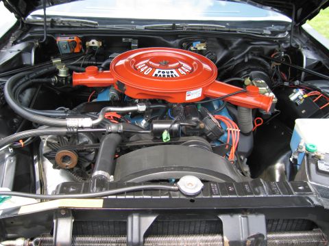 1991 Ford LTD Crown Victoria - Detail of an engine bay with an orange 440 Four Barrel air cleaner over a blue V8 and radiator below.
