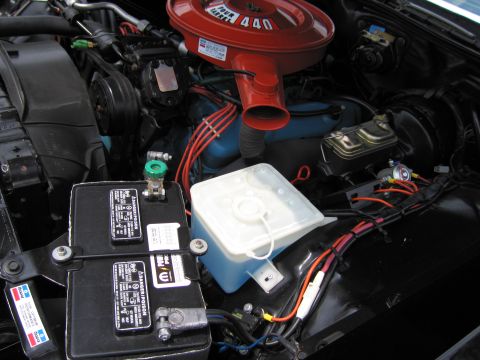 1991 Ford LTD Crown Victoria - Engine bay detail showing the battery, a white washer reservoir, and the orange 440 air cleaner snorkel.