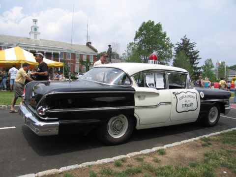 1991 Ford LTD Crown Victoria - black-and-white 1950s police sedan marked Schraalenburgh Township with a single red roof light.