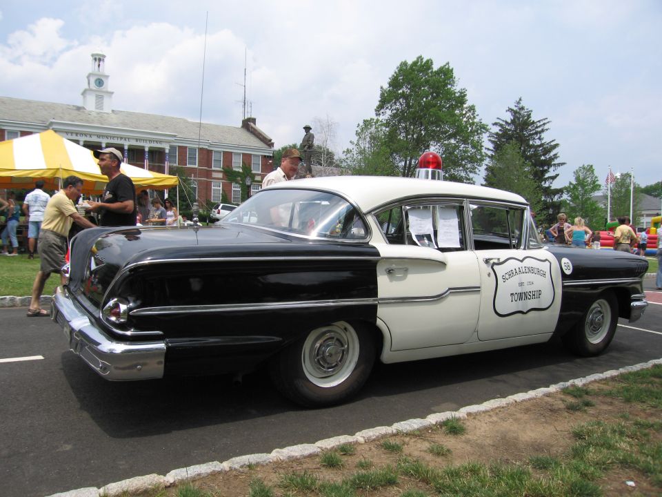Black-and-white 1950s police sedan marked Schraalenburgh Township with red light