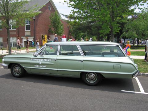 1991 Ford LTD Crown Victoria - green Ford station wagon lettered Stratford Police Radio Patrol shown in profile at a community event.