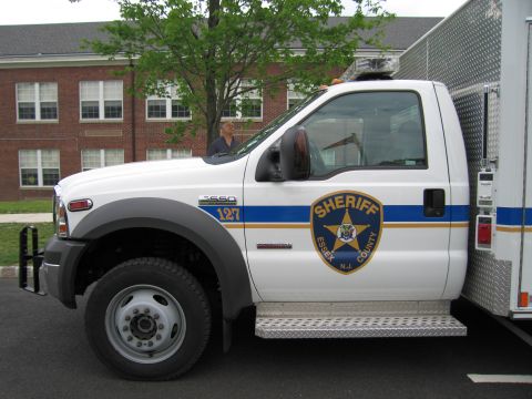 1991 Ford LTD Crown Victoria - Close driver-side view of a white Ford F-550 Essex County Sheriff truck cab with a blue stripe and gold star emblem.