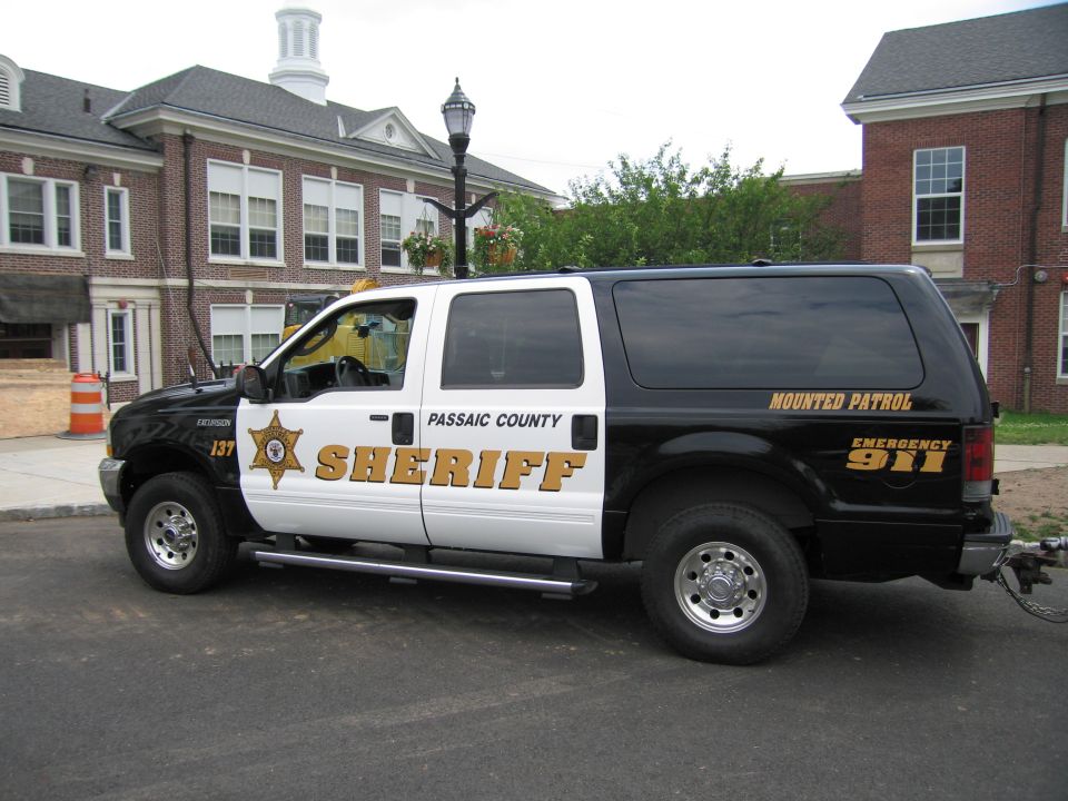 Black and white Passaic County Sheriff Ford Excursion SUV, driver-side profile