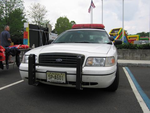 1991 Ford LTD Crown Victoria - Front view of a white Ford State Police Crown Victoria with push bar and NJ plate SP-A601, at an outdoor event.