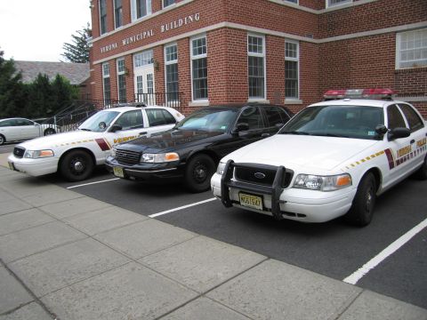 1991 Ford LTD Crown Victoria - Three police Ford Crown Victoria cruisers, white and black, parked in front of the Verona Municipal Building.