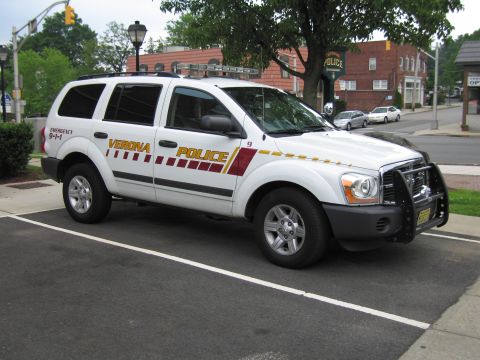 1991 Ford LTD Crown Victoria - Front three-quarter view of a white Verona Police Dodge Durango SUV with maroon striping, parked on a street.