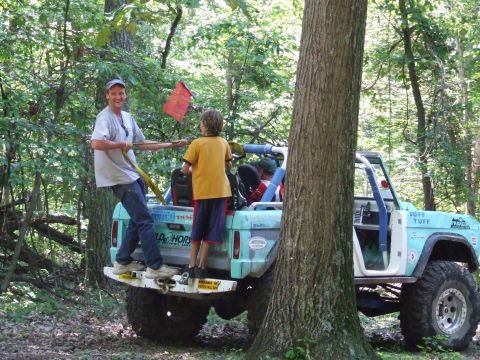 1967 Ford Bronco - A light blue 1967 Ford Bronco is parked in a wooded area with people in the back.