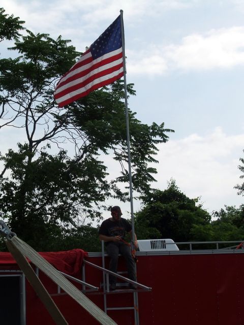 1967 Ford Bronco - American flag flies high above trees and a man on a platform, with the Supermotors logo visible at the bottom.