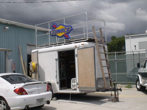 1993 Ford C-350 (Centurion Conversions) - A trailer with a Sunoco sign is set up with a viewing platform and ladder, with vehicles nearby.