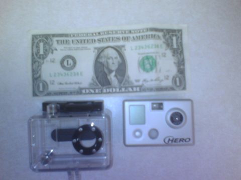 1984 Ford Bronco - A dollar bill is shown next to a GoPro camera and its waterproof housing.