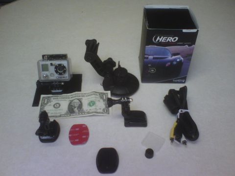 1984 Ford Bronco - A collection of GoPro camera accessories, including mounts and cables, are displayed with a one-dollar bill for scale.