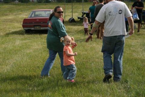 1990 Chevrolet Suburban - A red sedan is visible in the background of a grassy outdoor gathering.