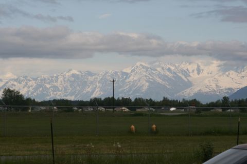 1990 Chevrolet Suburban - A scenic view of snow-covered mountains under a partly cloudy sky.