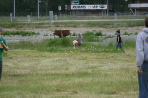 1990 Chevrolet Suburban - A group of children are playing in a field with a motel sign visible in the background.