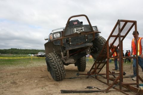 1990 Chevrolet Suburban - A modified off-road vehicle navigates a challenging obstacle during an event.