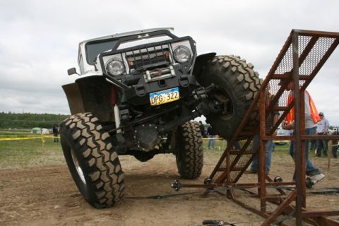 1990 Chevrolet Suburban - Custom off-road vehicle attempting an obstacle at an event.