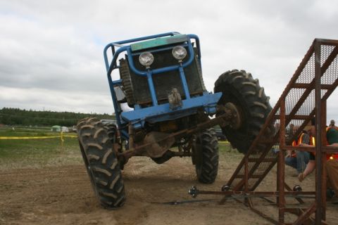 1990 Chevrolet Suburban - A custom-built off-road buggy is positioned on a metal ramp during an event.