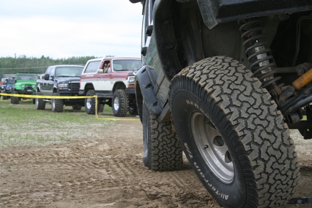 Line of off-road vehicles, close-up on front tire and suspension