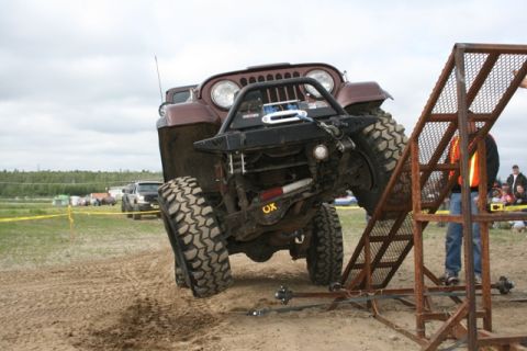 1990 Chevrolet Suburban - A modified Jeep CJ-7 navigates an obstacle course during an off-road event.