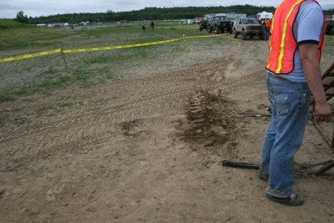 1990 Chevrolet Suburban - Several off-road vehicles are parked in a dirt field, with caution tape marking a boundary.