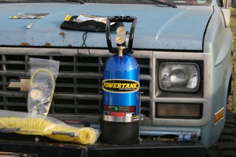 1990 Chevrolet Suburban - A blue Powertank air compressor and coiled yellow hoses are placed on the hood of a light blue truck.