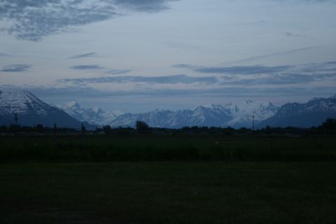 1990 Chevrolet Suburban - Mountain range visible at twilight with a dark foreground field.